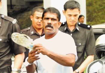 P. Joseph taking aim at the photographers with his slipper after the proceedings at the High Court.