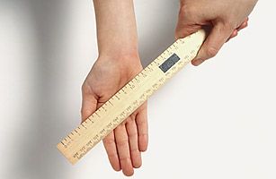 Posed pic of child's hand being struck with a ruler
