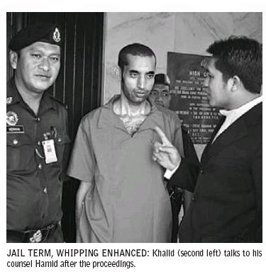 Khalid talks to his lawyer after the hearing